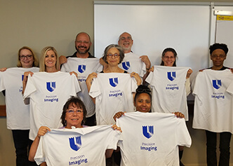 Pam Douglas, faculty director of the imaging department, shows off new shirts with the team in 2018.