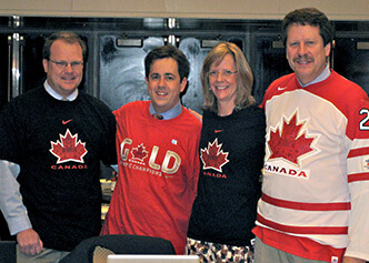 Craig Reist, Adrian Hernandez, Lisa Berdan, and Rob Califf sport Canadian hockey jerseys after a lost Olympics bet with collaborators from the Canadian Vigour Centre.