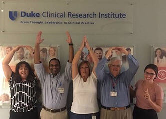 DCRI's Ohio State University alumni gathering prior to a retirement party in 2015 to spell out "OHIO."