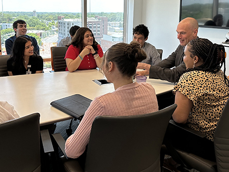 DCRI faculty mentor Danny Benjamin shares his insights with seven students sitting around a table.