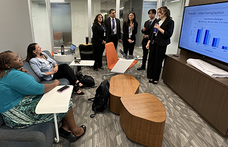 A cohort of STAR program participants dressed in business attire practice presenting their research to their mentors.