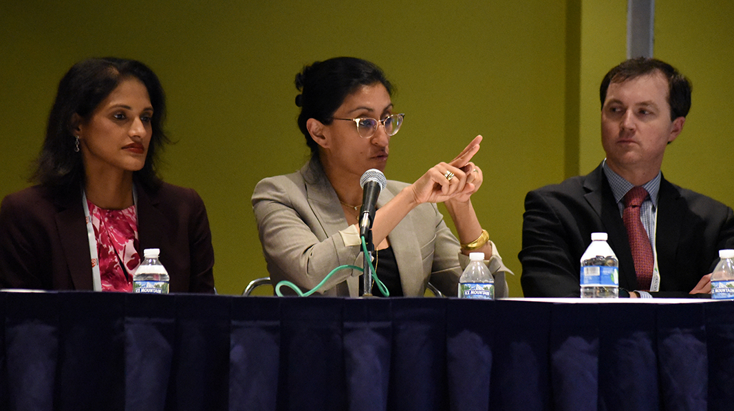 Neha Pagidipati speaks into a microphone as part of a panel discussion.