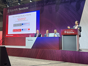 Renato Lopes stands at the podium on stage during a featured presentation at AHA25