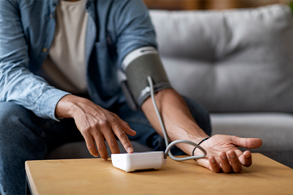 A person tests their blood pressure with a blood pressure cuff