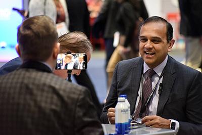 Manesh Patel laughs during an interview at the DCRI booth during ACC25.