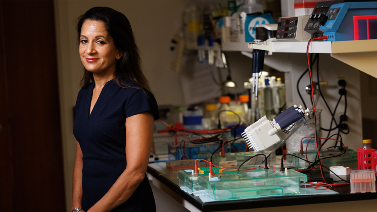 Svati Shah, MD, is shown with a smile leaning up against a lab desk.