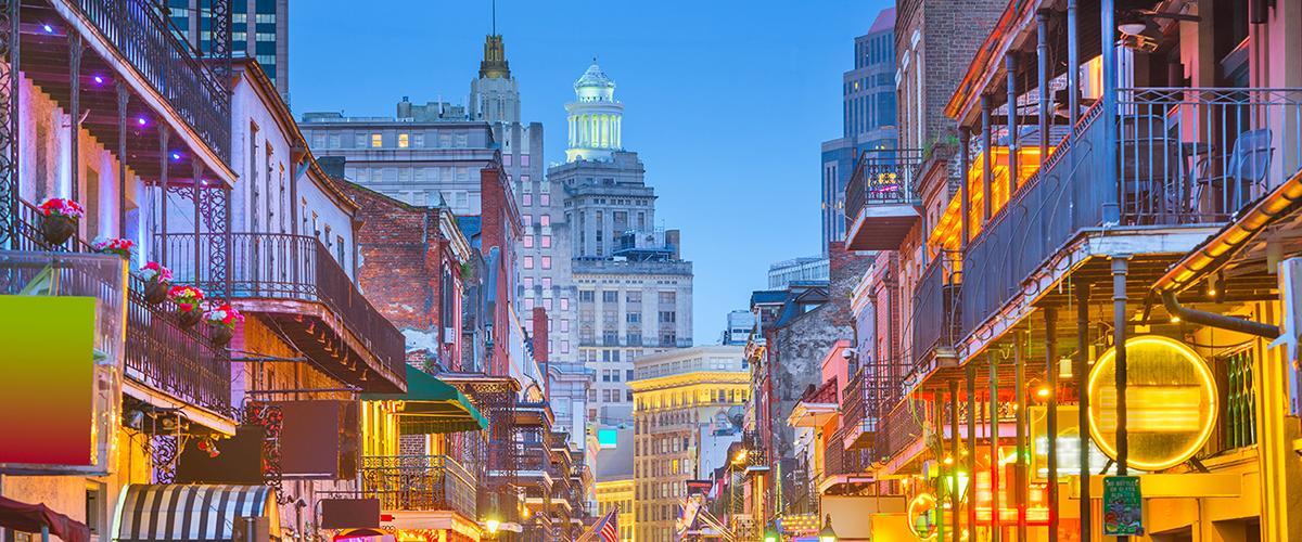 A colorful evening view of a street in New Orleans' French Quarter.