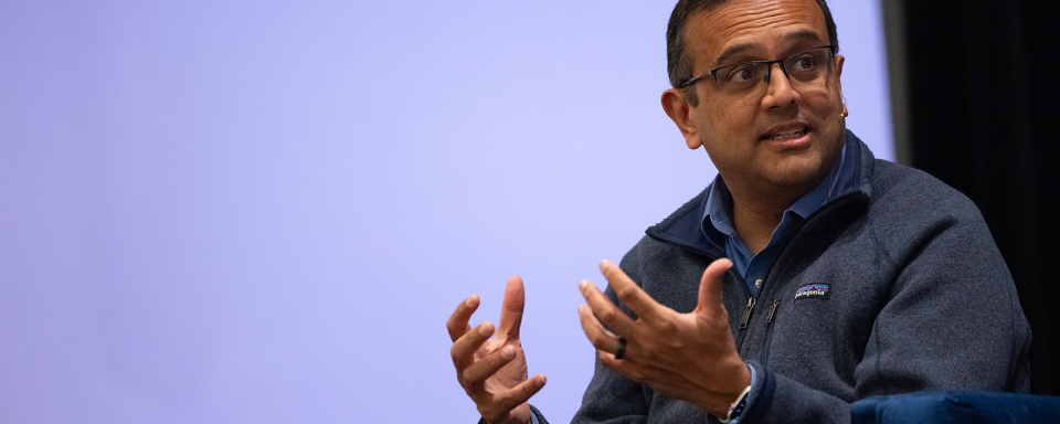 Manesh Patel sits on stage during a workshop emphatically sharing his knowledge.