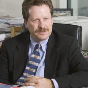 Archival image of Dr. Robert Califf, founding director of the DCRI and head of the FDA, sits at a desk speaking to someone off camera.