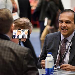 Manesh Patel laughs during an interview at the DCRI booth during ACC25.